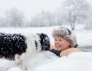 Vinterbadare med hund i snölandskap vid Simsjön i Skövde. 