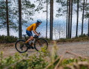 Kvinna cyklar på grusväg i Dalsland