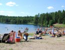 Människor som solar och badar en sommardag.