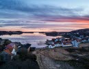 Vy över Bottnafjorden med Gerlesborg i förgrunden vid skymning. Rosa-lila himmel