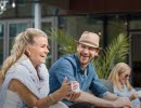 Two people sitting outside by a table and enjoying a fika