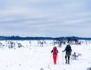 Två personer går i snöskor över det karga fjällandskapet på Blängsmossen.