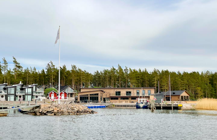 Vatten, byggnader, gästhamn, himmel och träd.