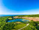 The old limestone quarry filled with clear blue water. The quarry is surrounded by green nature.