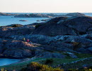 Three paople are hiking along a large cliff at North Koster. 