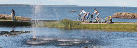 Two people bilking along the shore of Lake Vänern.