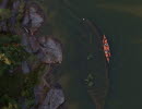 An overview of a ship wreck lying visible in a lake with a kayak on the side.