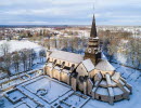 En stor stenkyrka och den intilliggande klosterruinen sedda från ovan. På marken ligger snö. 