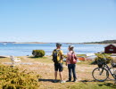 Two people are cycling on an island.