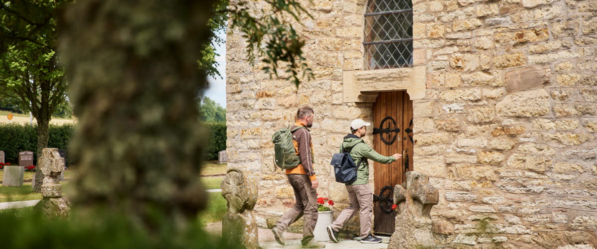 People hiking by Husaby church.